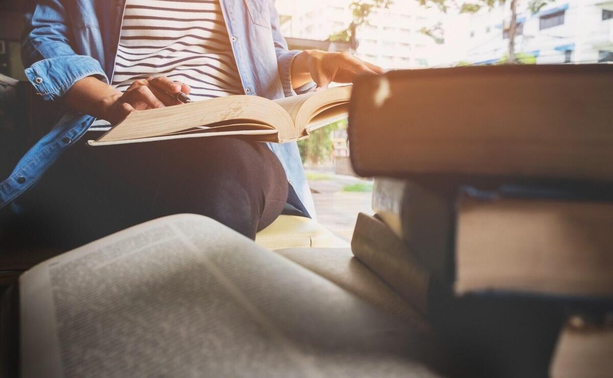 Woman sitting in a cafe, reading book