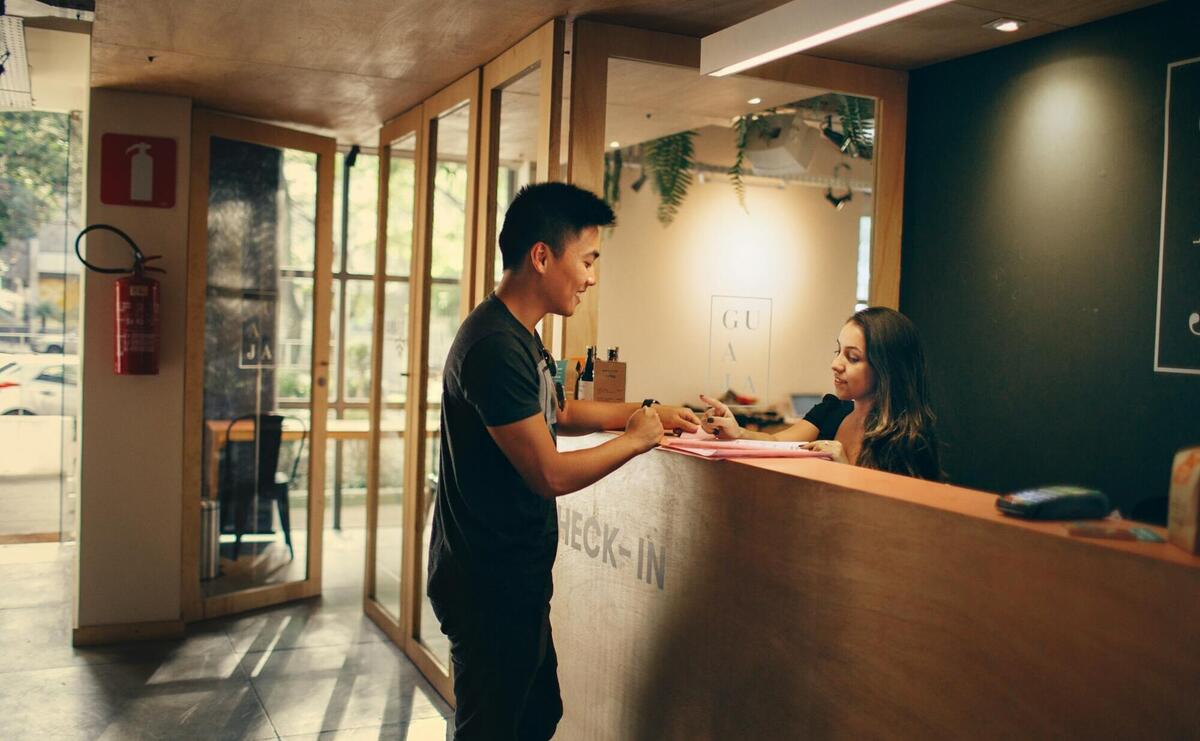 Guest is checking in to a hotel in the reception.