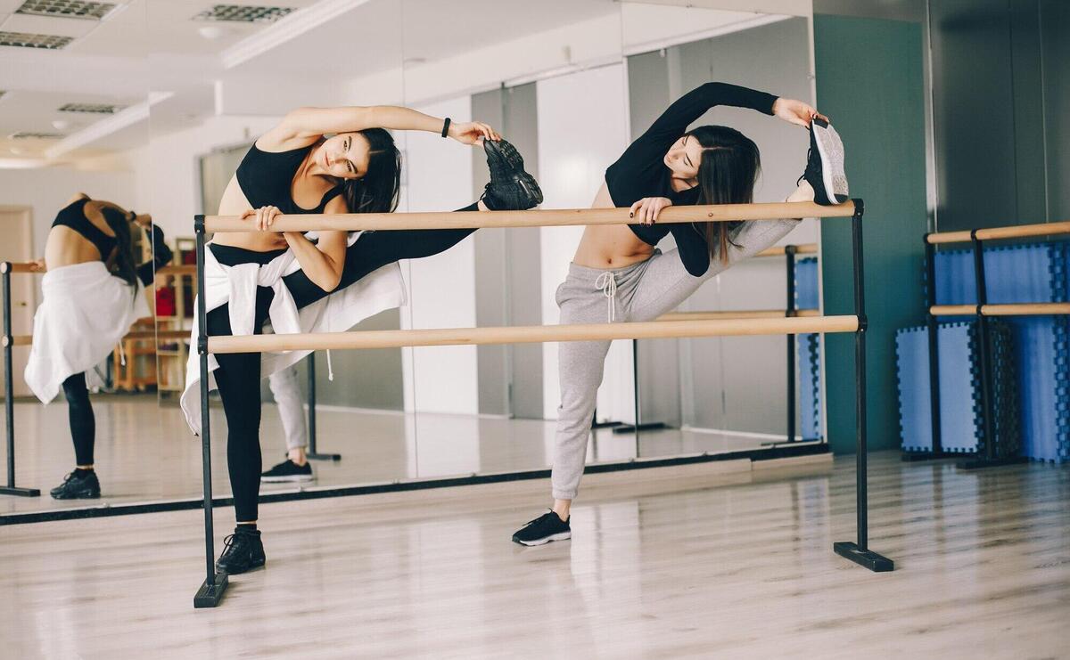 two beautiful slender girls doing dancing and gymnastics in the dance hall